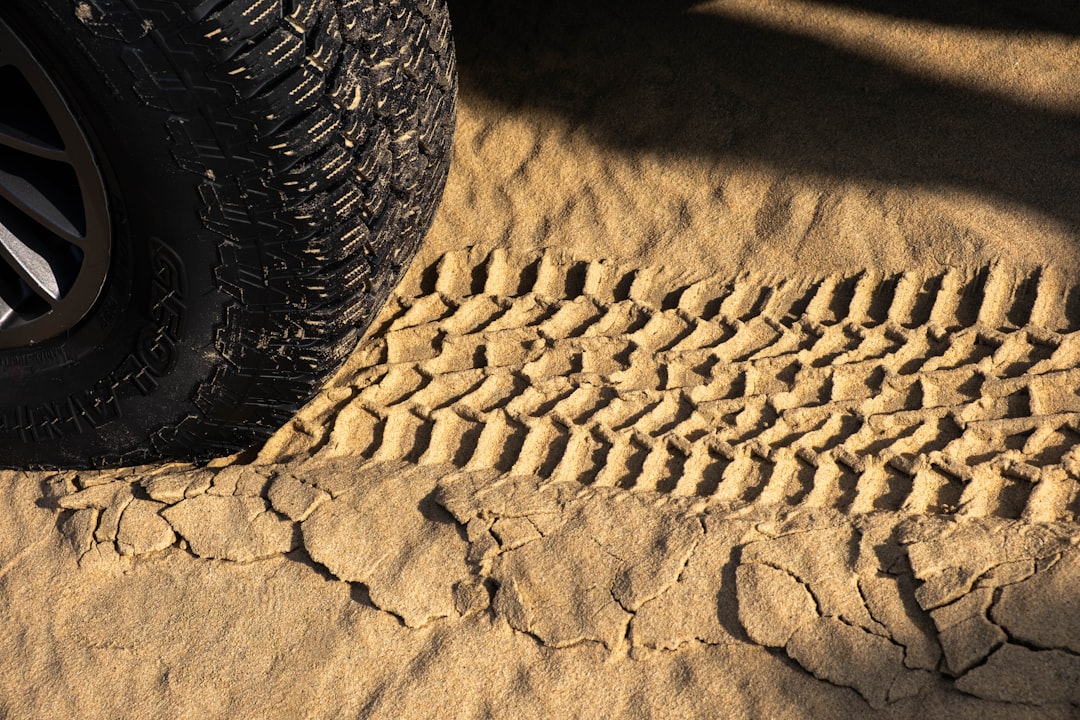 Kum zemininde off-road aracı lastik basıncını kontrol eden sürücü
